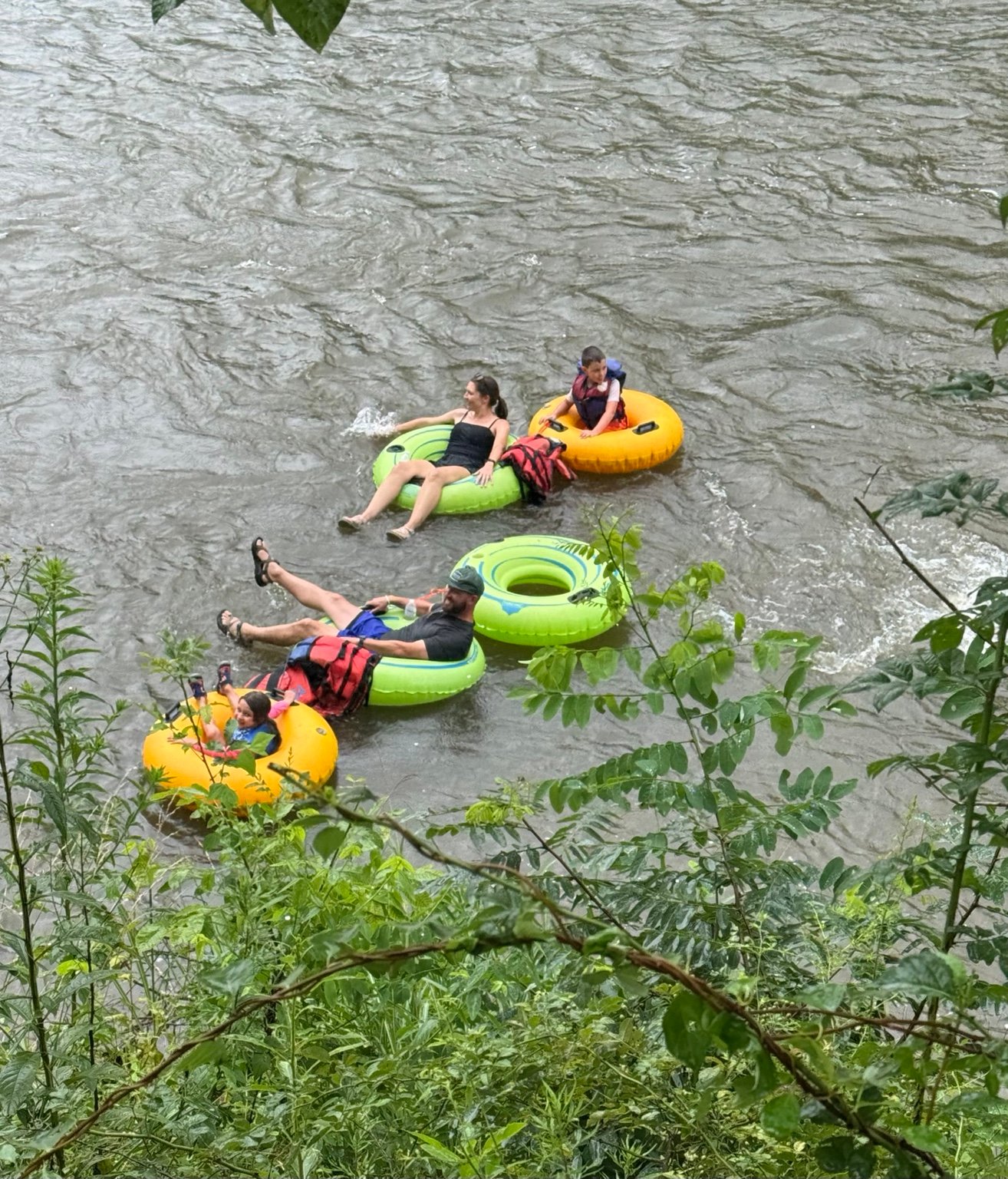 Family group floating in river tubes on the North Toe River near Bakersville, North Carolina