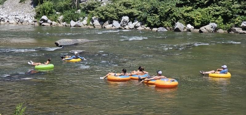 Tubers floating together on the North Toe River in Bakersville, North Carolina